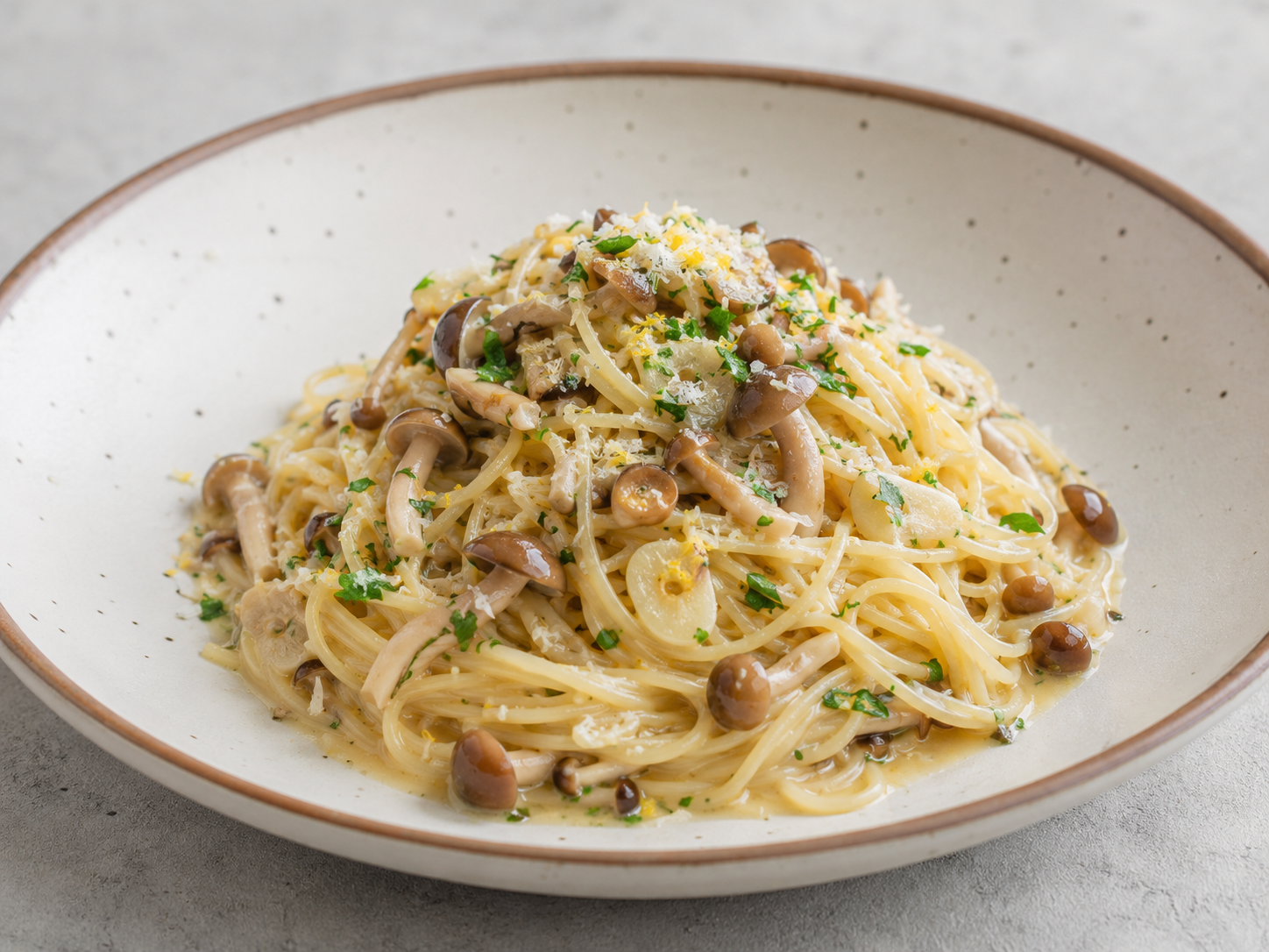 Plate of pioppino mushroom pasta finished with Parmesan and fresh basil